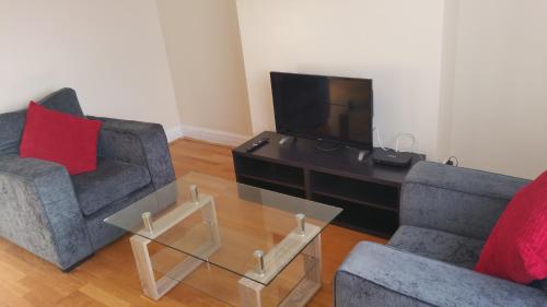 a living room with two chairs and a television at Elegant and spacious 2 bedroom in Barnet