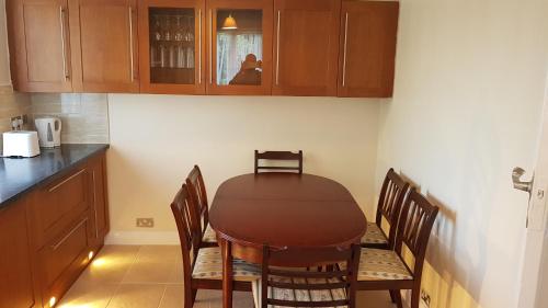 a kitchen with a table with chairs and cabinets at Elegant and spacious 2 bedroom in Barnet