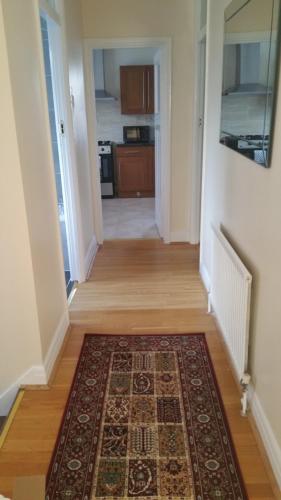 a hallway with a rug on a hard wood floor at Elegant and spacious 2 bedroom in Barnet