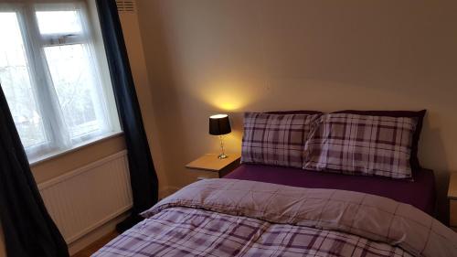 a bedroom with a bed with a pillow and a lamp at Elegant and spacious 2 bedroom in Barnet