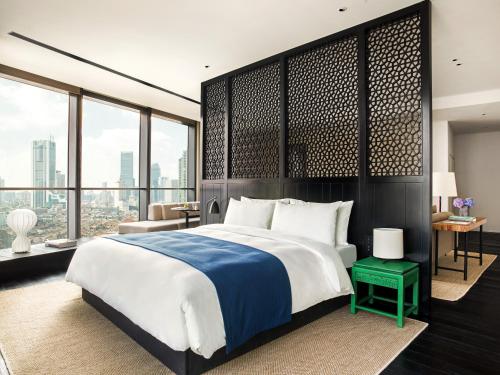 a bedroom with a large bed and large windows at The Middle House in Shanghai