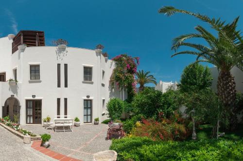 a white house with a palm tree and a courtyard at Torbahan Hotel in Torba