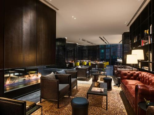 a hotel lobby with couches and tables and fireplaces at The Middle House in Shanghai