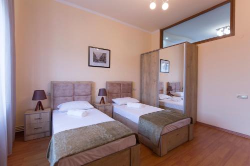 a bedroom with two beds and a large mirror at Umba Apartment N1 - 2 bedrooms in Yerevan
