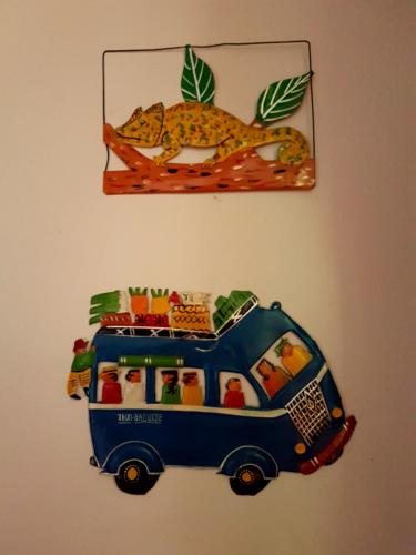 a toy bus is hanging on a wall at Hotel le Trianon in Antsirabe