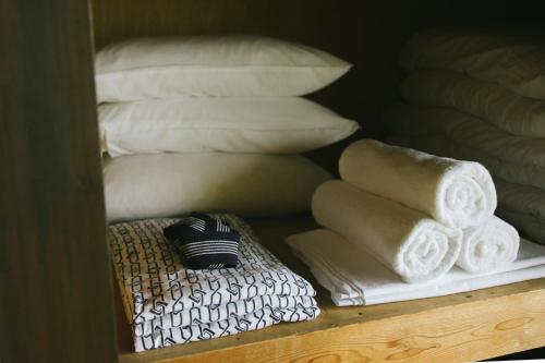 a shelf with towels and pillows in a room at Guesthouse tabi-tabi - walk to Ohama Beach - Max 12 ppl in Shimoda
