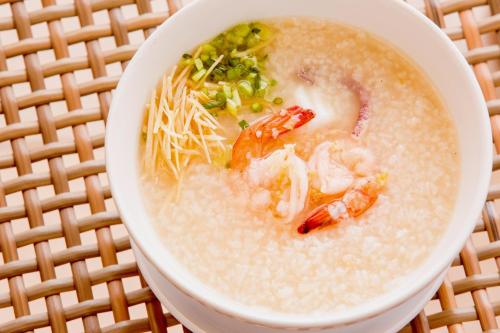 un tazón de sopa con camarones y verduras en una mesa en Ban Saithong Beach Resort, en Bang Saphan Noi