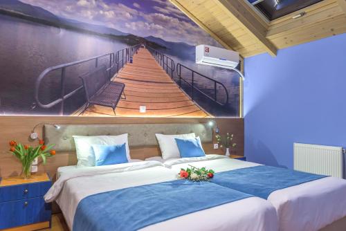 a bedroom with a painting of a wooden bridge at Sofia Apartments in Alexandroupoli