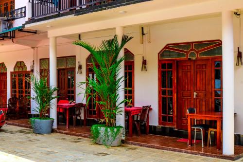 restauracja ze stołami, krzesłami i palmami w obiekcie Sevonrich Holiday Resort w mieście Dambulla
