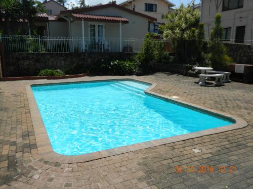 a swimming pool with blue water in a yard at Driftsands Sea View Flats in Uvongo Beach
