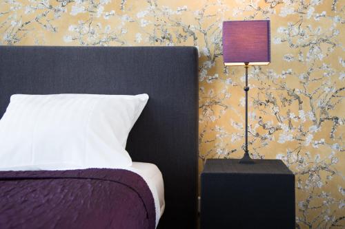 a bedroom with a bed and a lamp next to a wall at Hotel Zilt in Vlissingen