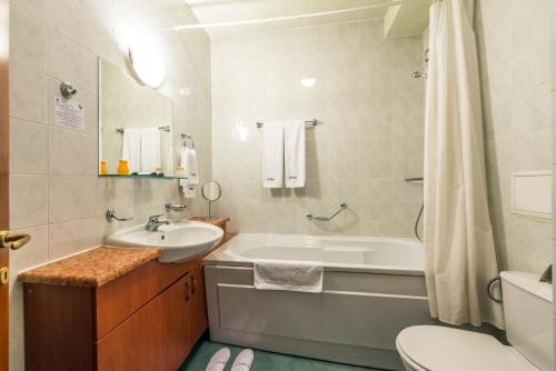 a bathroom with a tub and a sink and a toilet at Sveta Sofia Hotel in Sofia