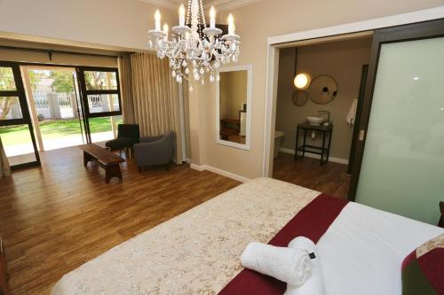 a bedroom with a large bed and a chandelier at Boutique Guesthouse Mariental in Mariental