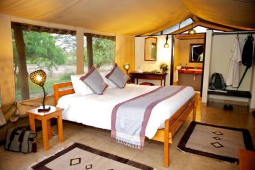 a bedroom with a large bed in a tent at Voyager Ziwani Tented Camp in Ziwani