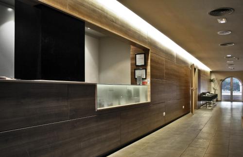 a hallway with a large television on the wall at Hotel Canal Olímpic in Castelldefels