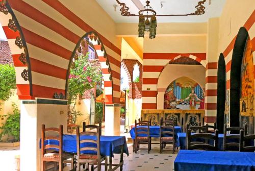 restauracja z niebieskimi stołami i krzesłami w pokoju w obiekcie Hotel Sheherazade Luxor w mieście Luksor