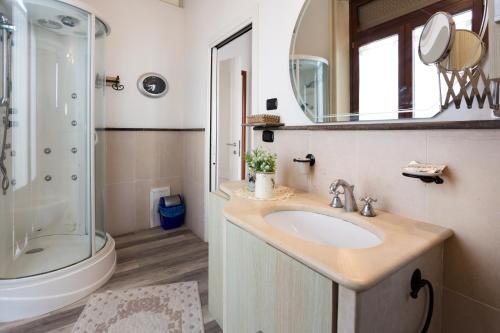 シラクーサにあるB&B Ortigia Beddaのバスルーム(シンク、シャワー、鏡付)