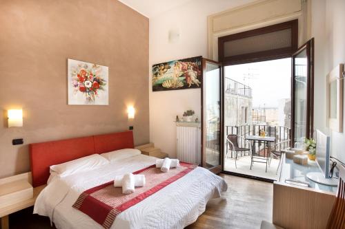 a bedroom with a large bed and a balcony at B&B Ortigia Bedda in Syracuse