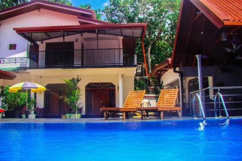 a swimming pool with a blue and white pool table and chairs at Sevonrich Holiday Resort in Dambulla