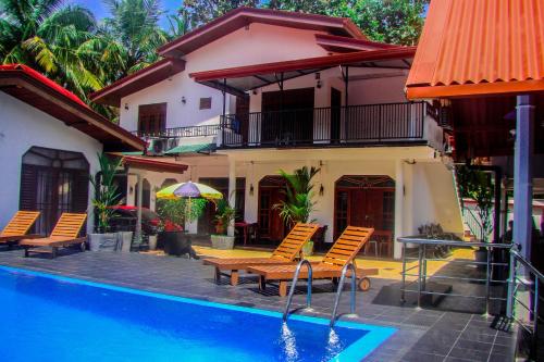 a house with a swimming pool in front of a house at Sevonrich Holiday Resort in Dambulla