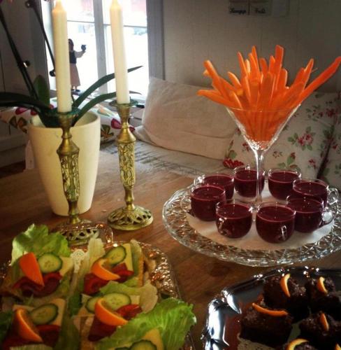 a wooden table with plates of food and candles at Norrsjön in Sörsjön