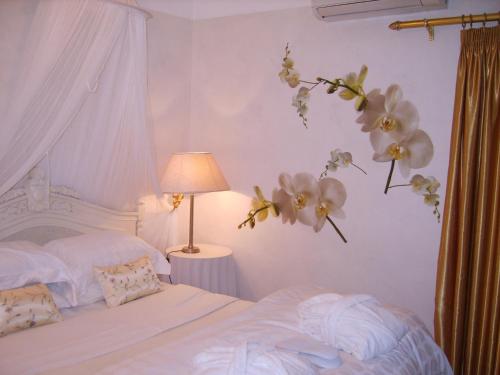 1 dormitorio con 1 cama con flores en la pared en Emerald Guest House Springs, en Springs