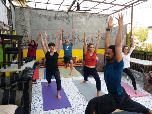 a group of people doing yoga in a yoga class at Backpackers Villa Mumbai in Mumbai