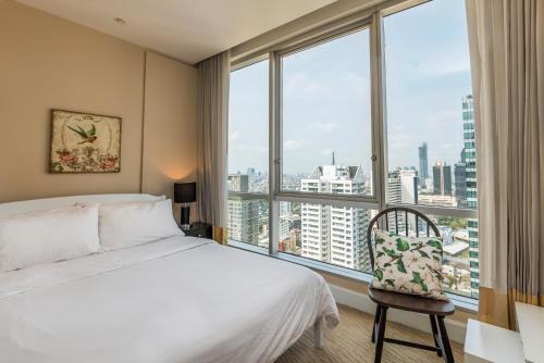 a bedroom with a bed and a large window at Sky Villas Apartments in Bangkok