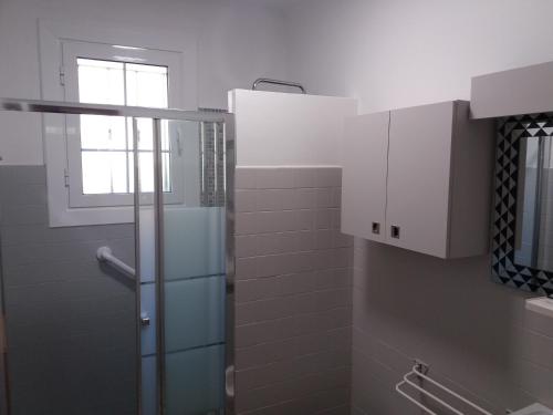 une salle de bain avec une douche avec une porte vitrée dans l'établissement Appts maison Onbor Zilo, à Biriatou