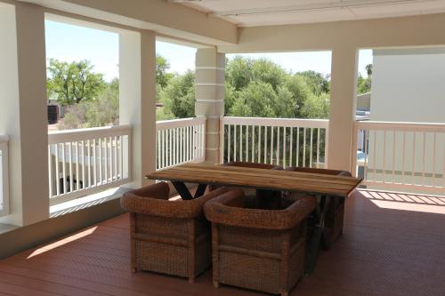 a screened in porch with a wooden table and chairs at Boutique Guesthouse Mariental in Mariental