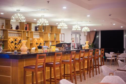 a bar with wooden chairs and chandeliers at Vinh Hoang Hotel in Dong Hoi