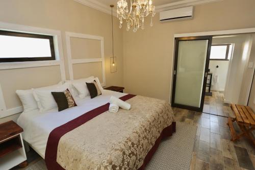 a bedroom with a large bed and a chandelier at Boutique Guesthouse Mariental in Mariental