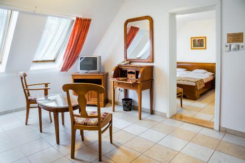 a bedroom with a mirror and a desk and a bed at Kata Panzió in Szeged