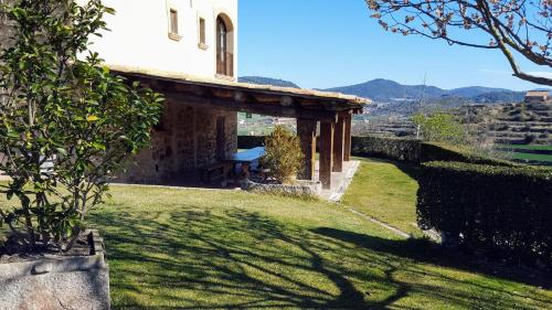 a building with a bench on the side of a yard at La Torre Blanca in Cardona