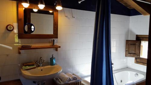 a bathroom with a sink and a mirror and a tub at La Torre Blanca in Cardona