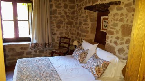 a bedroom with a bed and a stone wall at La Torre Blanca in Cardona