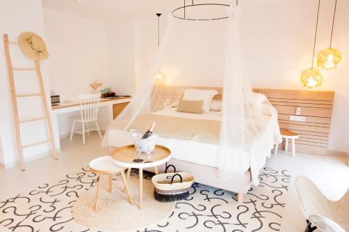 a bedroom with a bed with a mosquito net at Gatzara Suites Santa Gertrudis in Santa Gertrudis de Fruitera