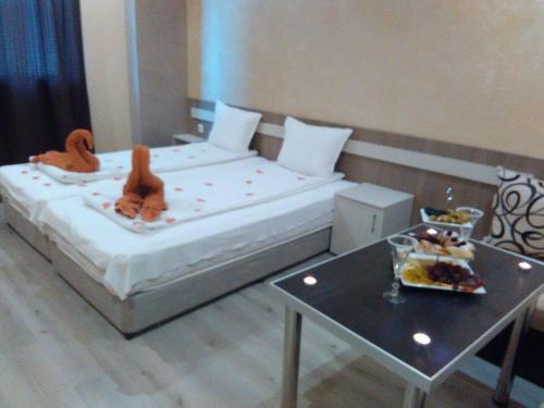 a bedroom with a bed with stuffed animals on it at Семеен Хотел Русалка in Svishtov