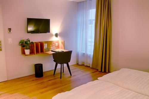 a bedroom with a bed and a desk with a computer at Gasthof Mühle in Aesch