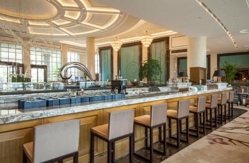 ein Restaurant mit einer Bar mit Hockern in der Unterkunft Radisson Blu Hotel Wuhan ETD Zone in Wuhan