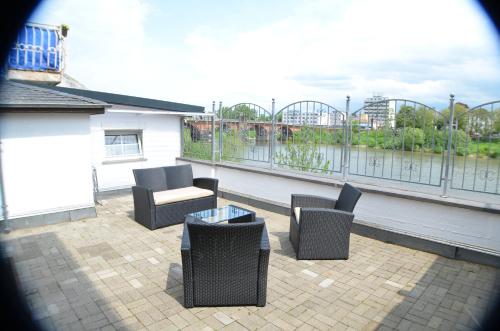 Un patio con sillas y una mesa en el balcón. en Ferienwohnung Römerbrücke, en Trier