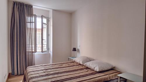 カンヌにあるTrès Joli T3 Vieux Port Cannesの白いベッドルーム(ベッド1台、窓付)