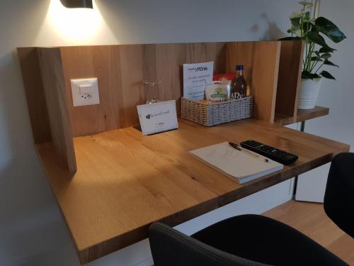 a desk with a bottle of wine and a remote control at Gasthof Mühle in Aesch