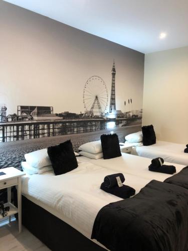 three beds in a room with a ferris wheel in the background at Happy Return Hotel in Blackpool