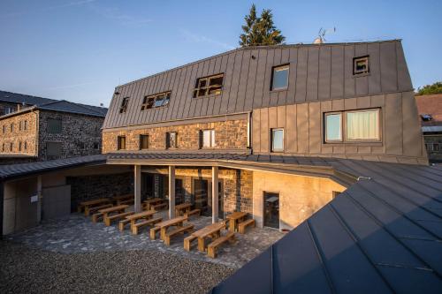 a house with wooden benches on the roof of it at Galyatető Turistacentrum in Galyatető