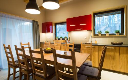 a kitchen with red cabinets and a wooden table and chairs at Galyatető Turistacentrum in Galyatető