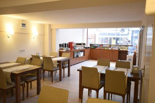 comedor con mesas y sillas y cocina en Parion House Hotel, en Canakkale