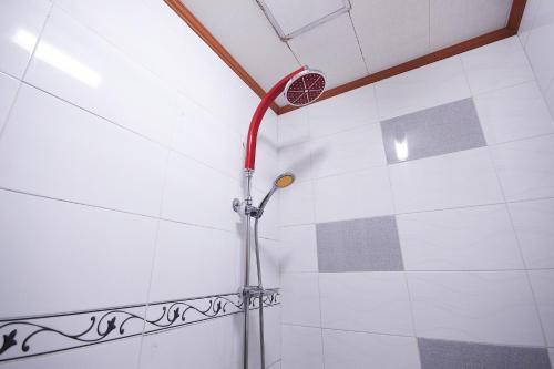 a shower with a red shower head on a wall at Happy Q Motel in Andong