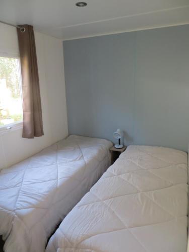 a bedroom with two beds next to a window at Hebergement dans un Domaine à Litteau in Litteau