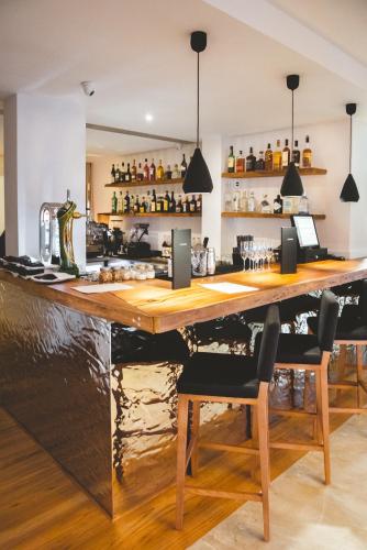 a bar with a large wooden counter and chairs at Lagos Avenida Hotel in Lagos
